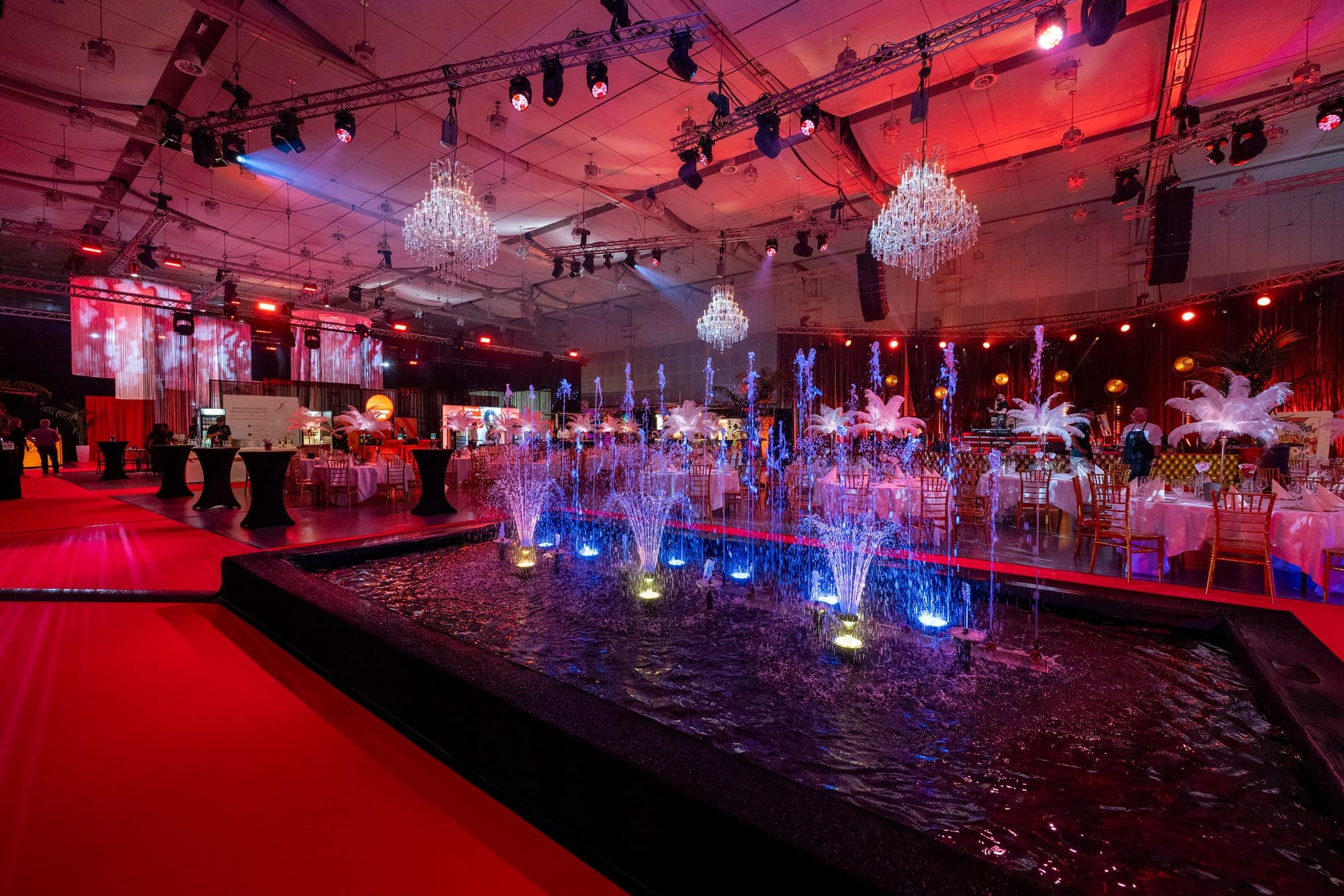 Festsaal mit Wasserspiel und Kronleuchtern im roten Licht