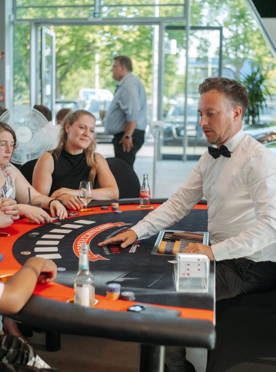 Croupier leitet eine Blackjack-Runde im Autohaus